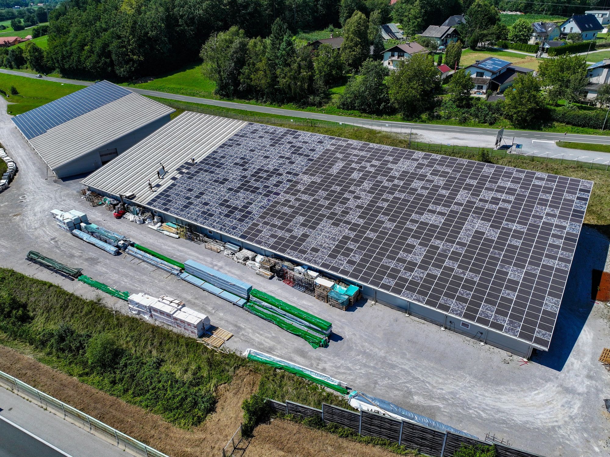 Technician replacing damaged solar panels on an industrial rooftop